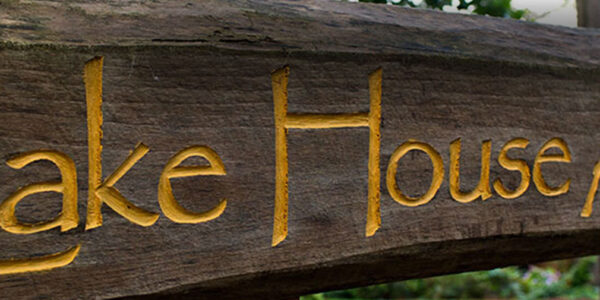 Wooden welcome sign at Lake House Academy
