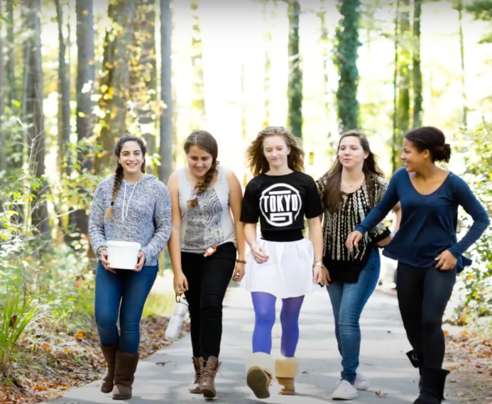 Several girls enjoying a walk along a paved path through the woods at Lake House Academy.